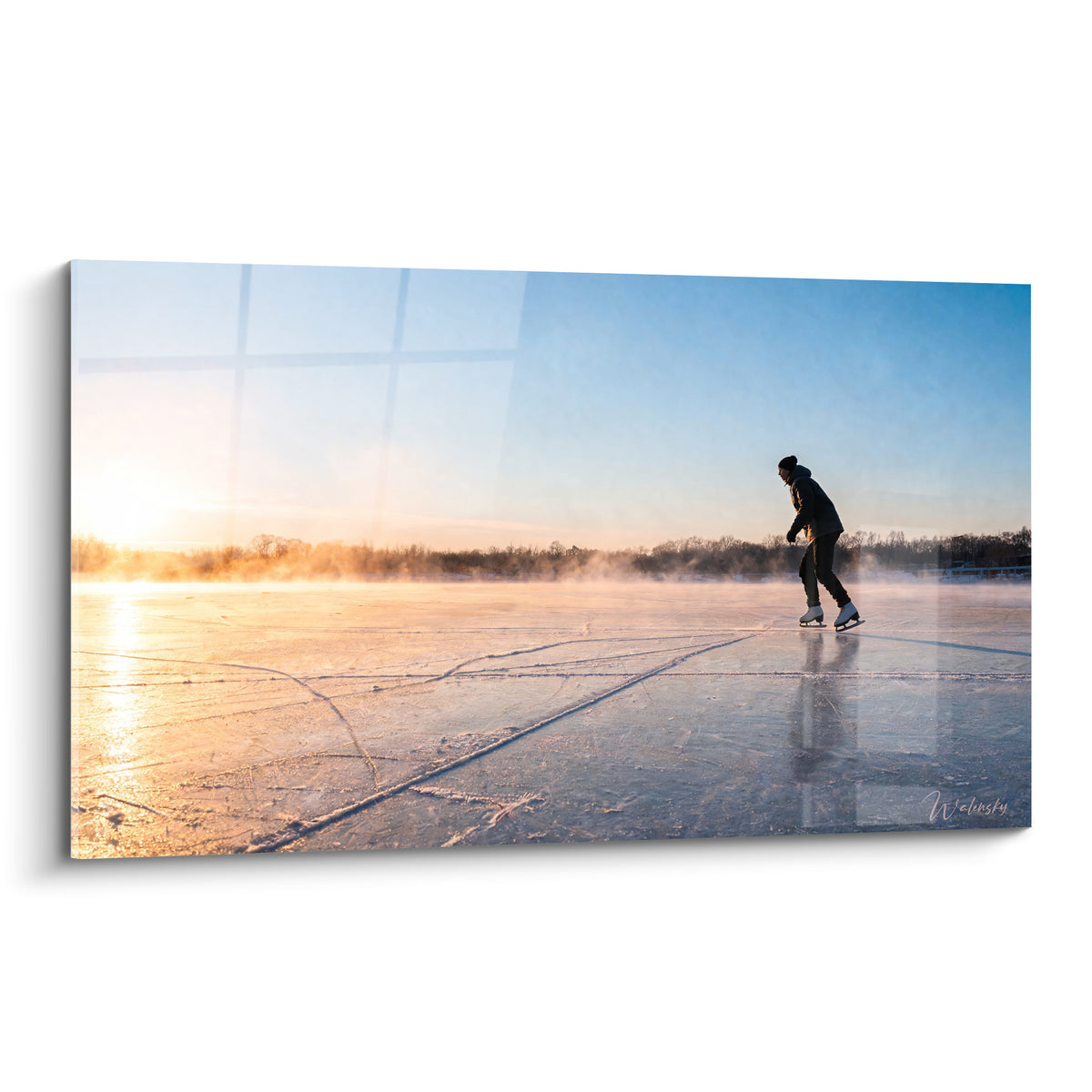 Patineur en silhouette anthracite glisse sur lac gelé doré, ciel bleu pastel à l'aube brumeuse