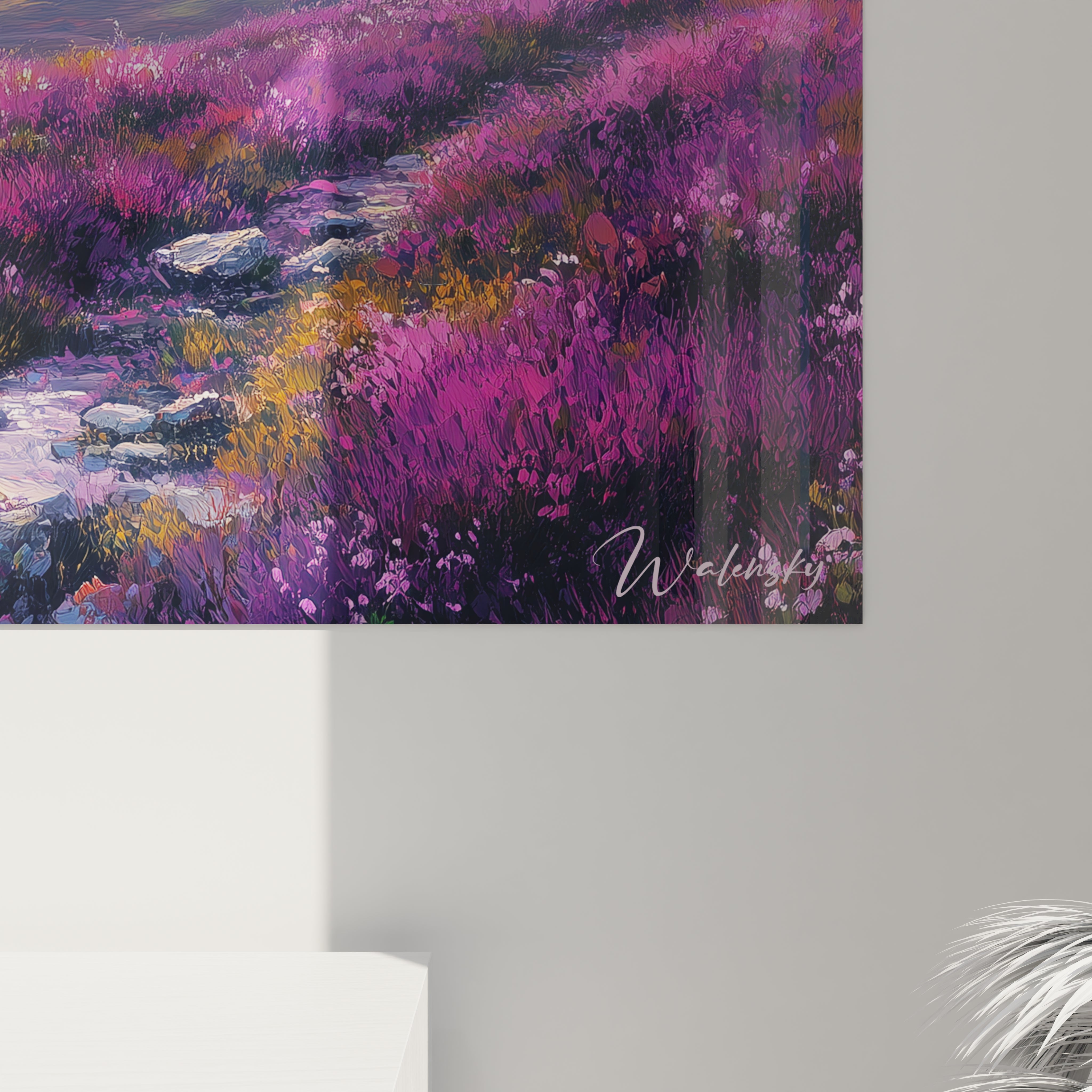 Un tableau montagne montrant une composition avec des prairies alpines densément fleuries en violet, rose et rouge au premier plan, s'étendant jusqu'à des reliefs montagneux bleus sous un ciel dégradé orange et jaune pâle.