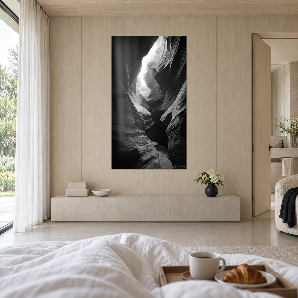 Schilderij golvende rotsdoorgang, wit licht dat uit een scheur stroomt op houtskoolkleurige achtergrond, boven een bed in een lichte slaapkamer