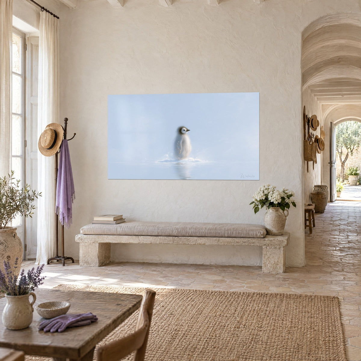 Tableau bébé manchot au duvet crème et bec sombre, ciel bleu pâle, reflet sur l'eau, face au couloir voûté du mas provençal