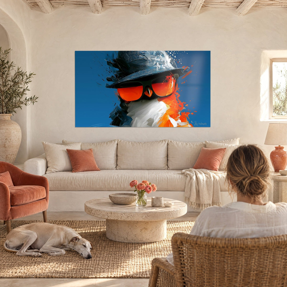 Tableau oiseau coiffé d'un chapeau bleu ardoise et lunettes orange vif, plumage blanc, au-dessus d'un canapé dans un salon lumineux