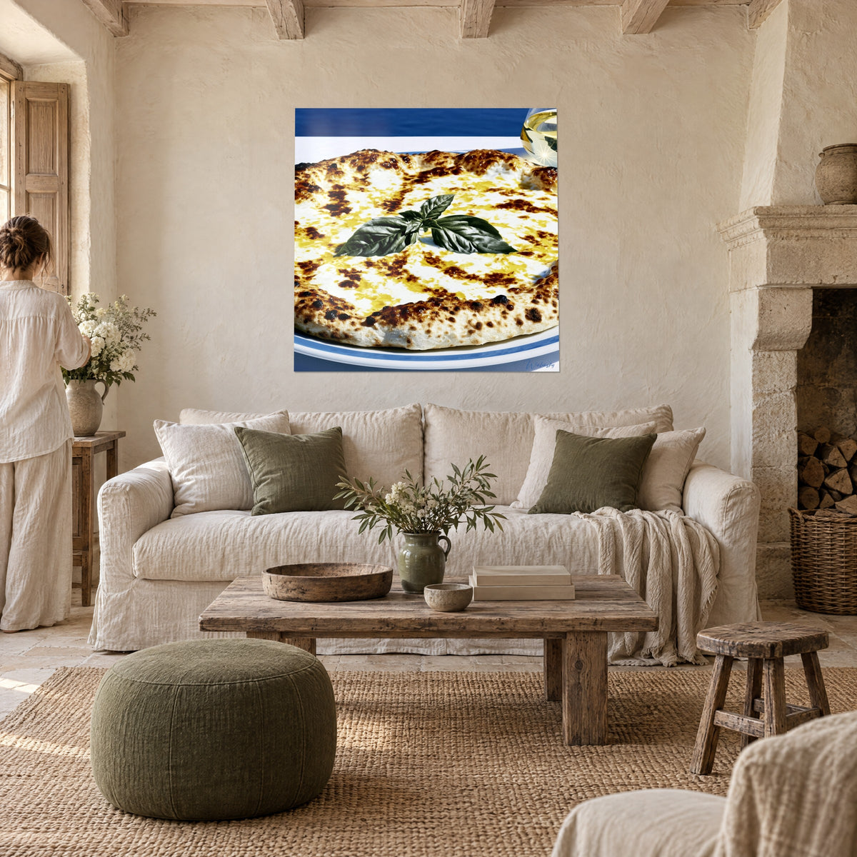 Schilderij witte gouden pizza, donkergroene basilicum en okerkleurige verbrande rand, boven een bank in een lichte woonkamer