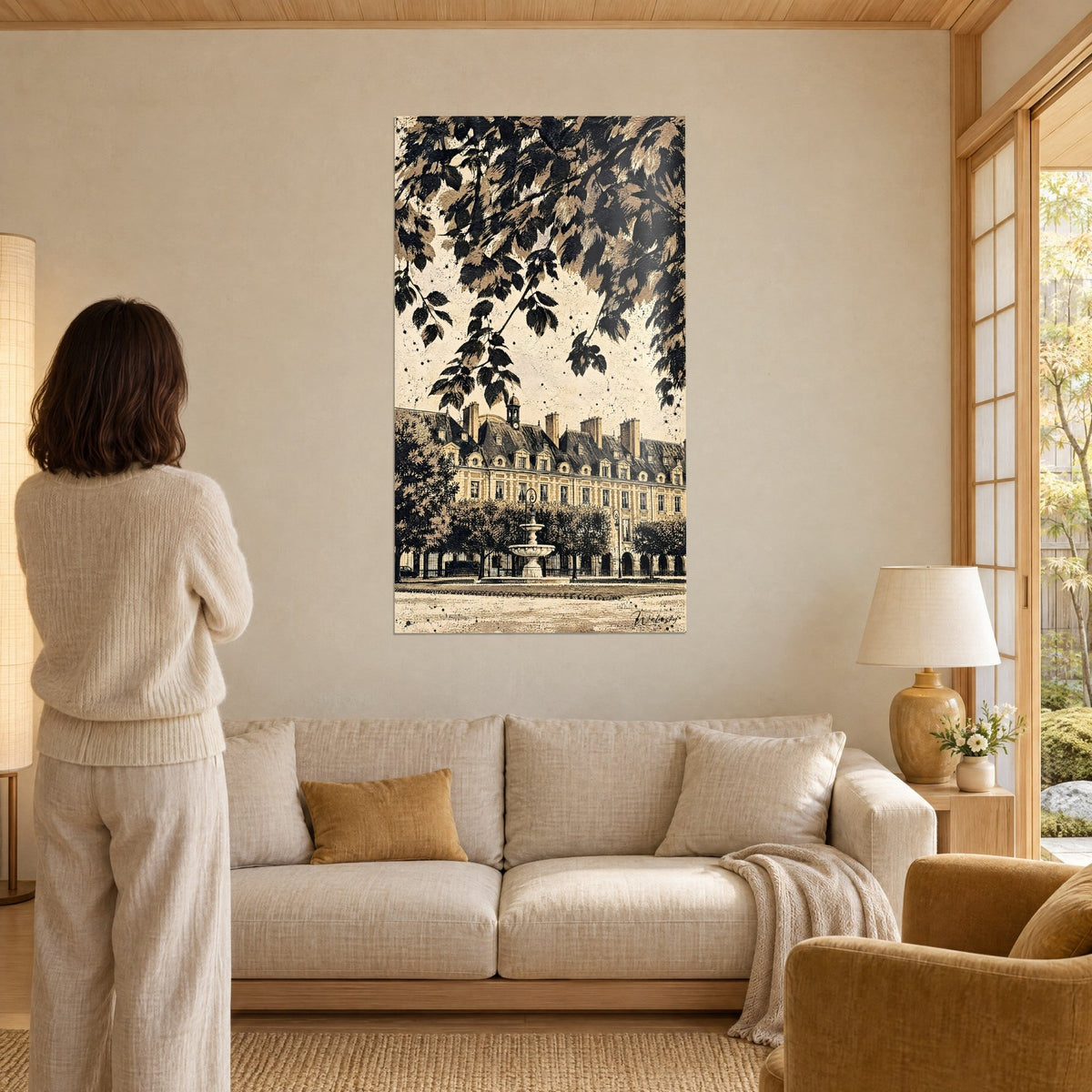 Quadro facciata in mattoni e pietra della Place des Vosges in seppia e nero, fronde in alto, donna di spalle, sopra un divano in un soggiorno luminoso
