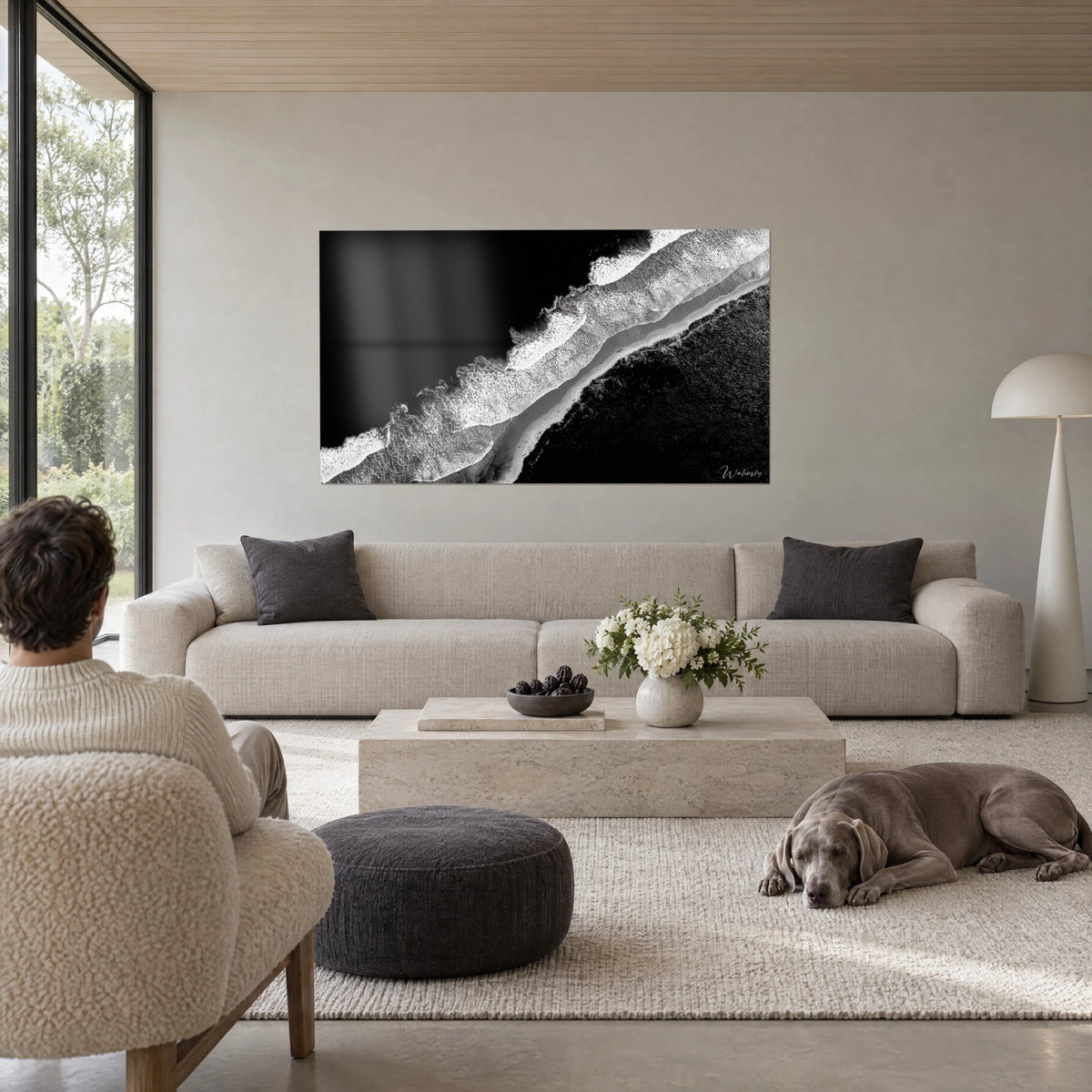 Tableau rivage aérien en noir et blanc, écume blanche sur sable gris et mer d'encre, au-dessus d'un canapé dans un salon lumineux