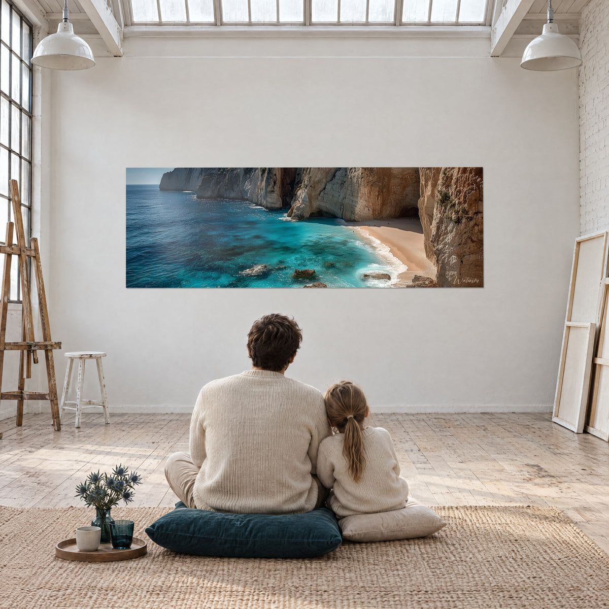 Wall art of a dreamlike cove with crystal-clear turquoise waters, golden sand and tall orange cliffs, a couple seen from behind seated on a blue cushion