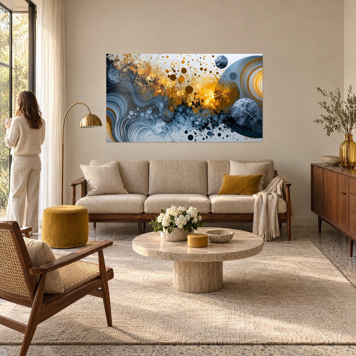 Schilderij abstract kosmos in oker en leisteenblauw, gemarmerde bollen en gouden druppels, vrouw van achteren boven een bank in een lichte woonkamer