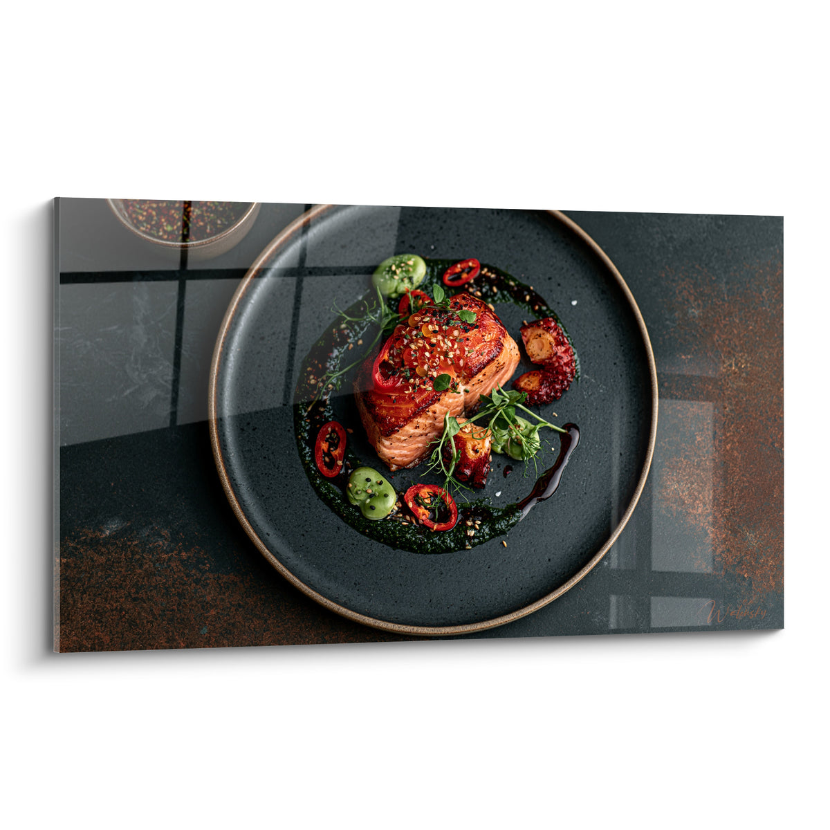 Saumon laqué terracotta sur assiette anthracite, piments rouges et herbes fraîches disposés en cercle