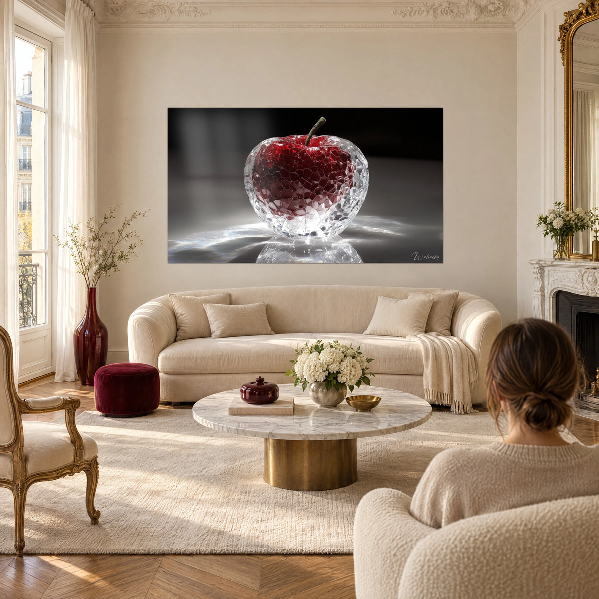 Cuadro manzana de cristal facetada, corazón rojo granate sobre fondo negro, encima de un sofá en un salón luminoso