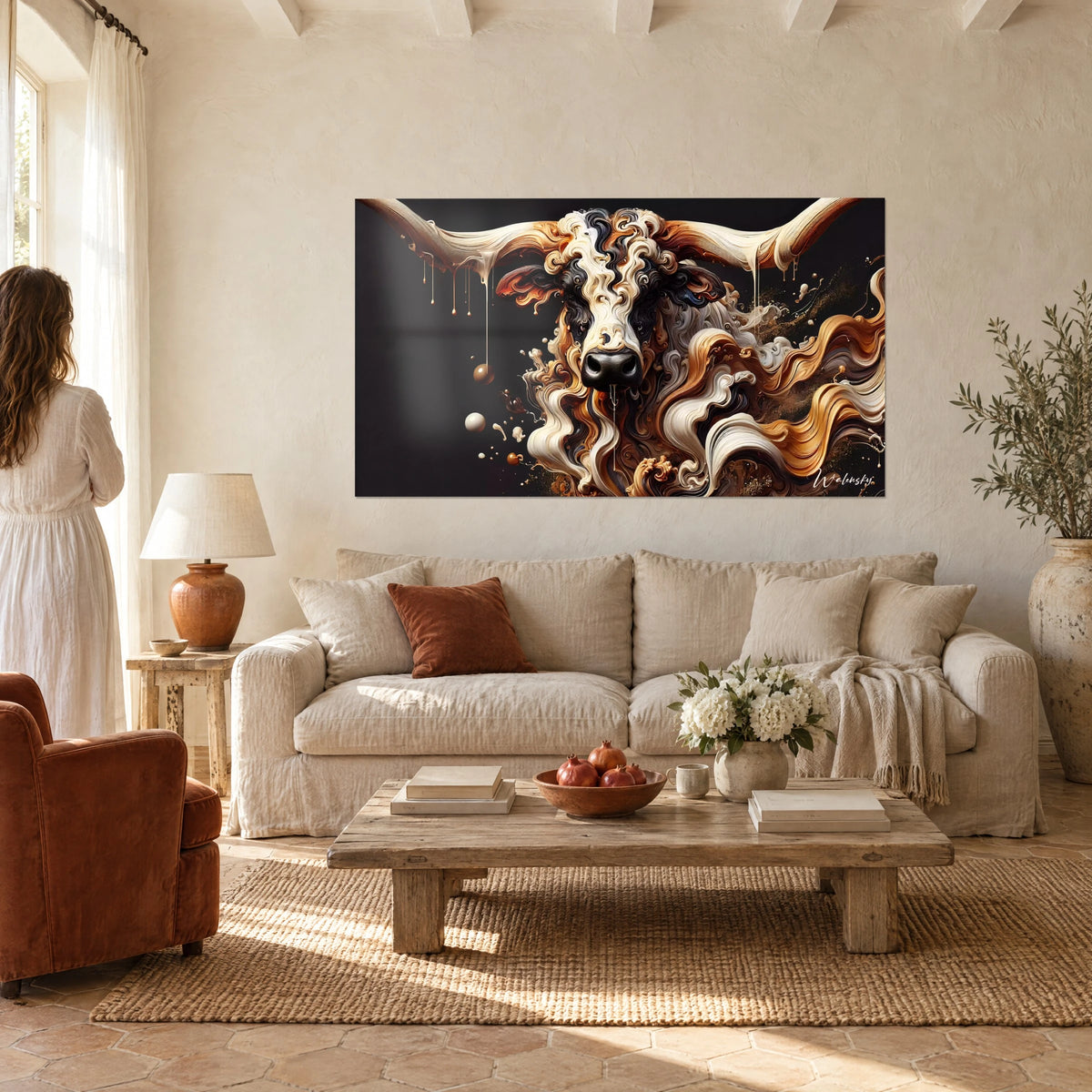 Schilderij van een stier met lange ivoorkleurige hoorns, vacht van crèmekleurige en koperen krullen op een zwarte achtergrond, boven een bank in een lichte woonkamer