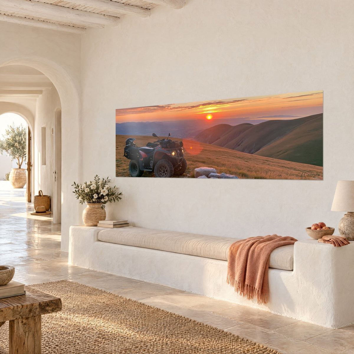 Wall art of a dark off-road vehicle facing a red and amber sunset, violet valleys, on the white wall of a Mediterranean house