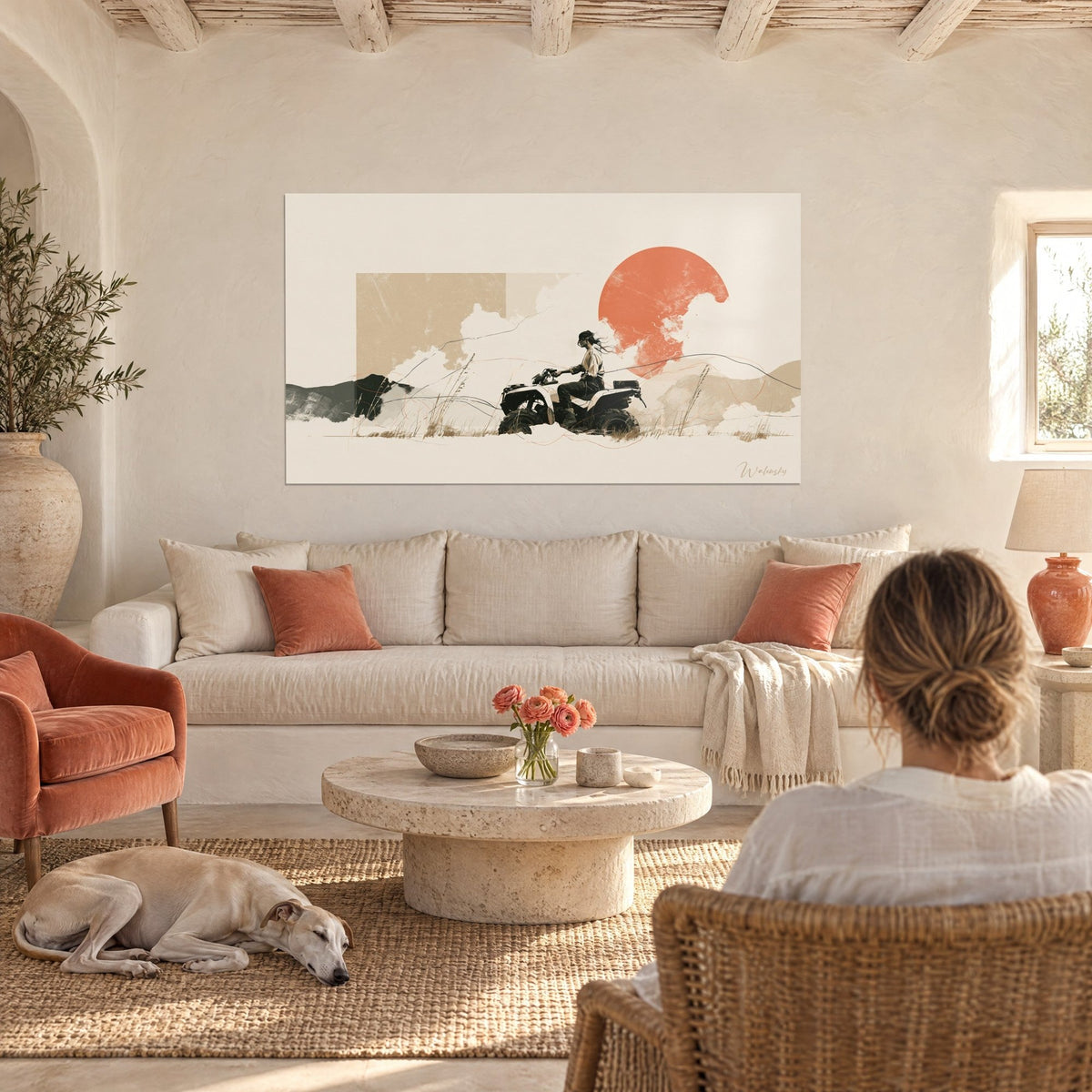 Wall art quad rider under a terracotta orange sun on a cream background, two people seen from behind, above a sofa in a bright living room
