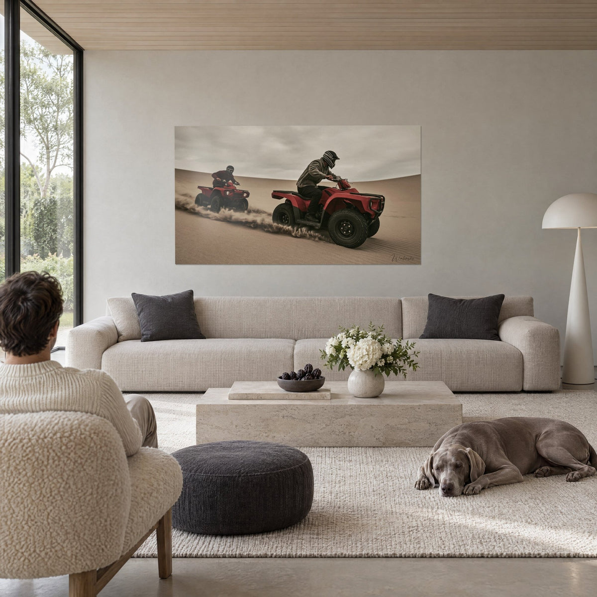 Tableau quads rouges lancés sur une dune, sable beige soulevé, ciel gris, au-dessus d'un canapé dans un salon lumineux