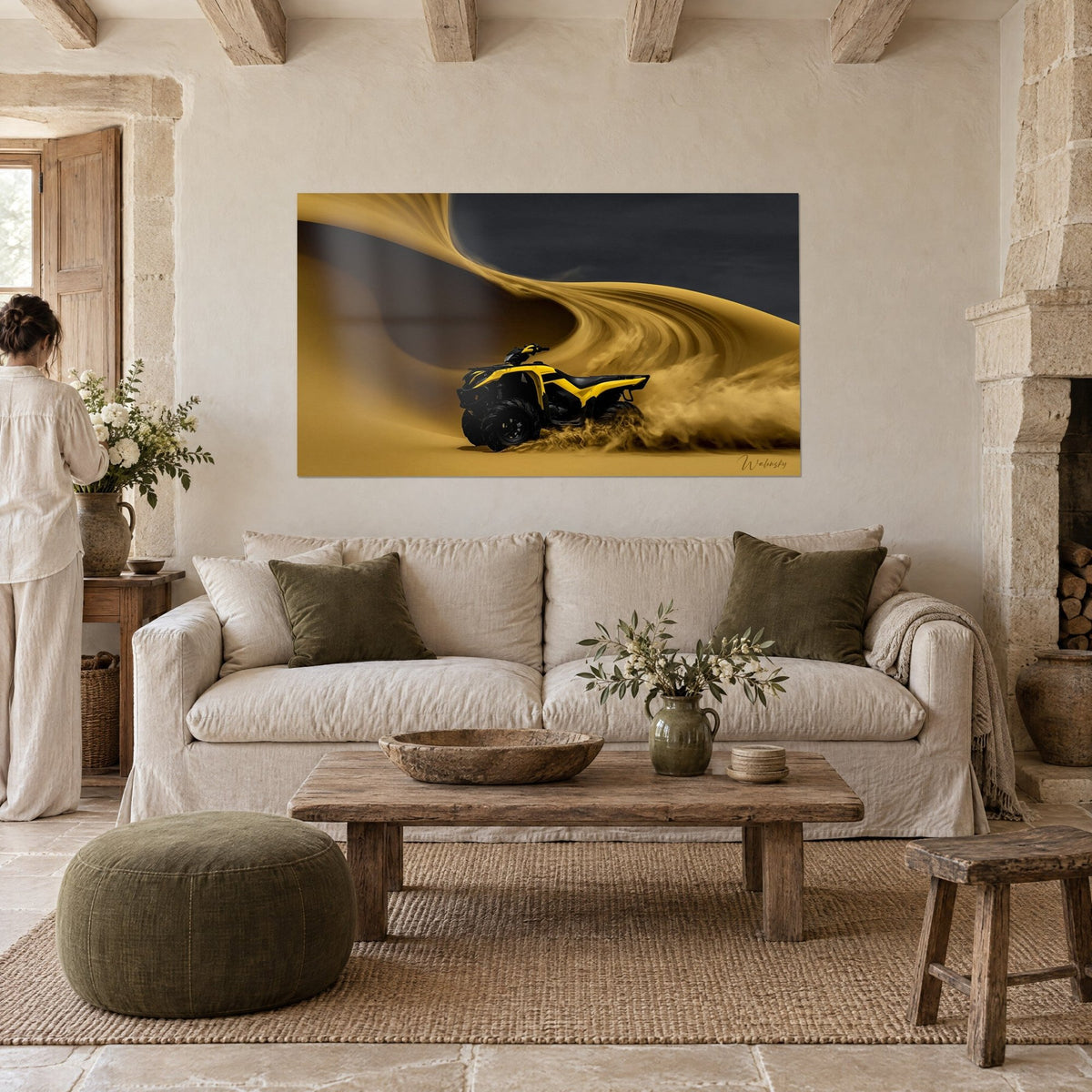Wall art: Bright yellow quad racing down a golden dune, sand spraying from the wheels, woman seen from behind, above a sofa in a bright living room