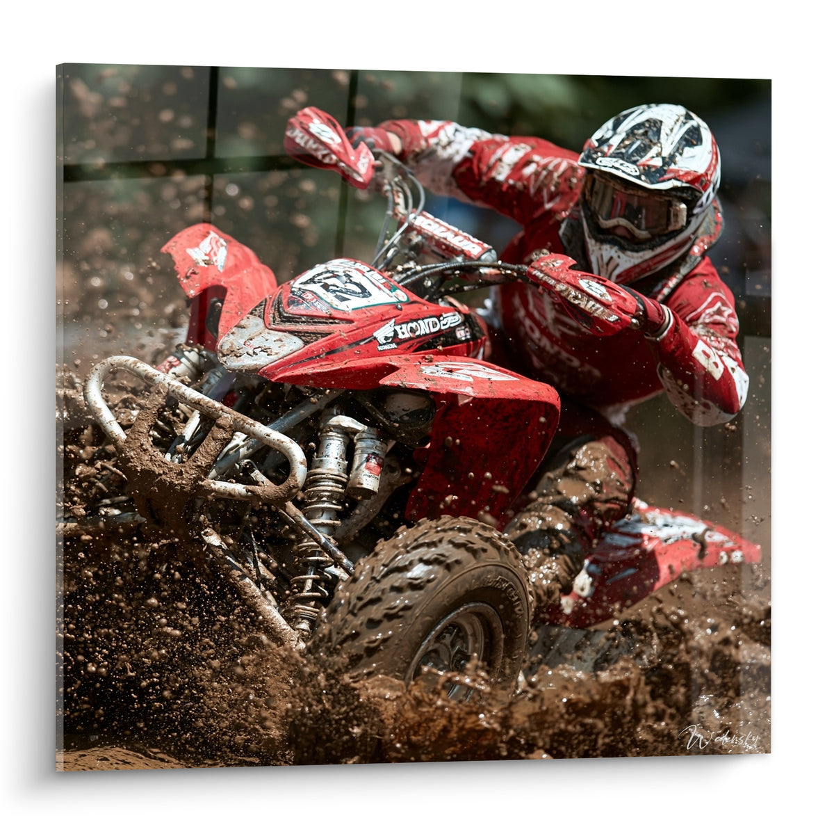 Quad rouge et blanc projetant une boue marron sous un pilote penché en plein virage