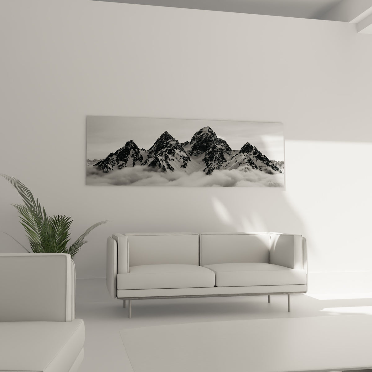 Chaîne montagneuse noire et blanche percée de nuages, au-dessus d'un canapé dans un salon lumineux