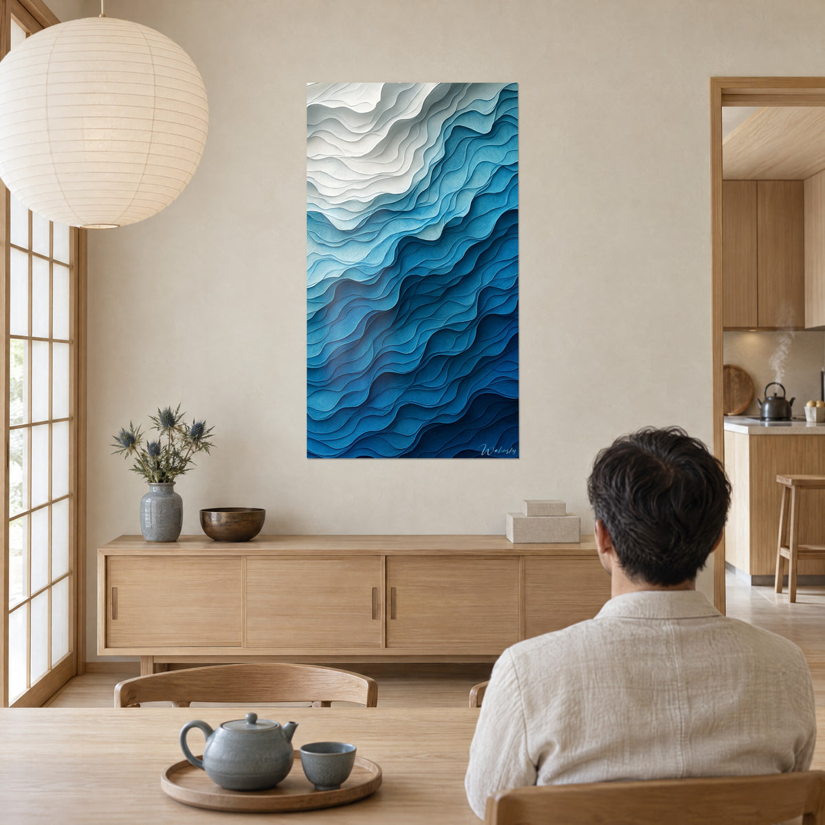 Schilderij met gelaagde papieren golven, helder cyaan en petroleumblauw, man van achteren voor een lage houten dressoir en een lantaarn