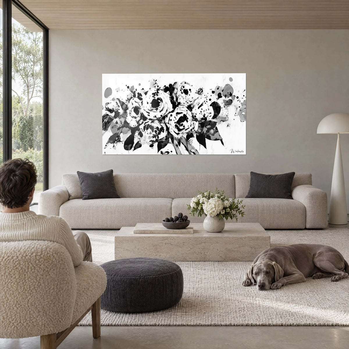Cuadro ramo de rosas salpicado en blanco y negro, manchas de tinta sobre fondo blanco, encima de un sofá en un salón luminoso