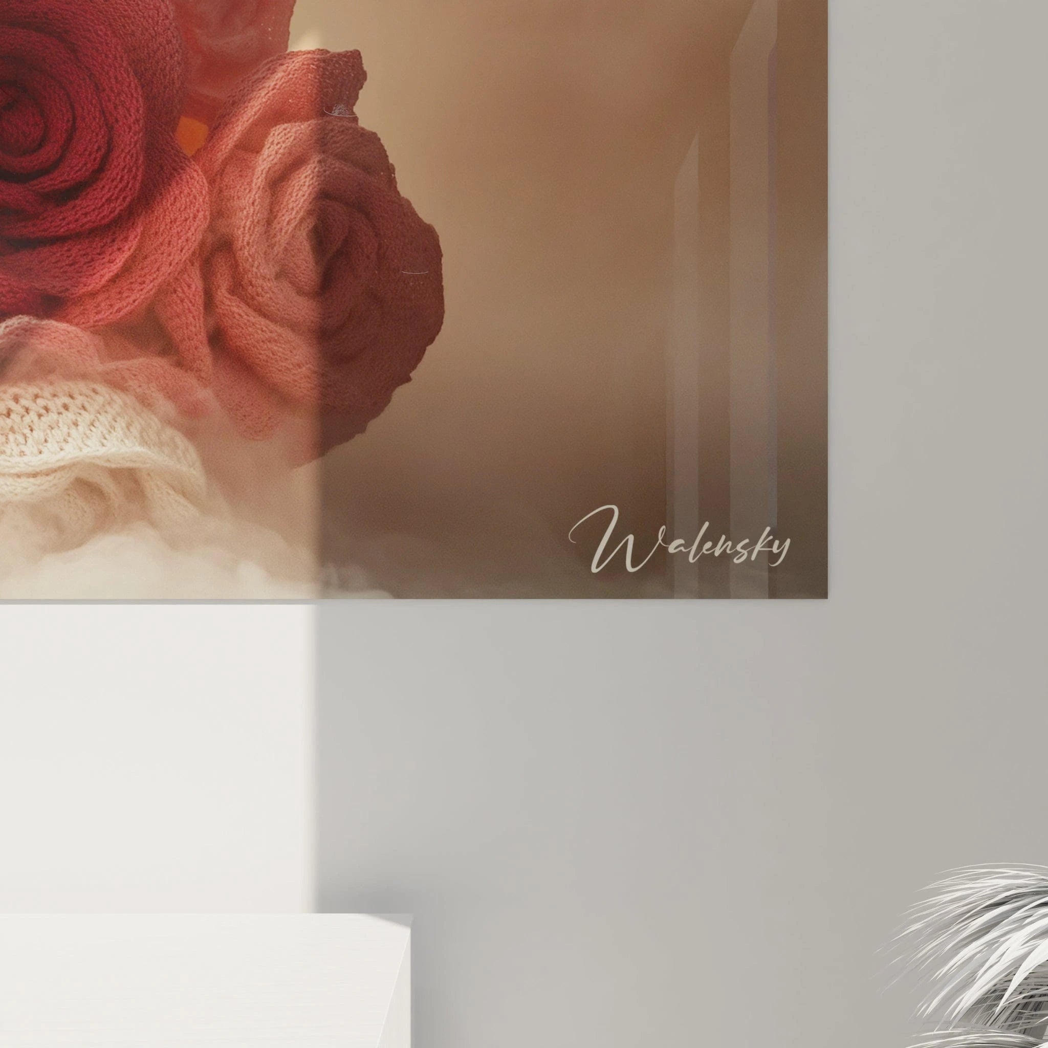 Un tableau de roses crochetées regroupant des fleurs textiles rouges, roses et blanches aux détails minutieux, où chaque pétale présente une texture maillée caractéristique, créant un contraste tactile avec la douceur lumineuse du fond beige ambré.