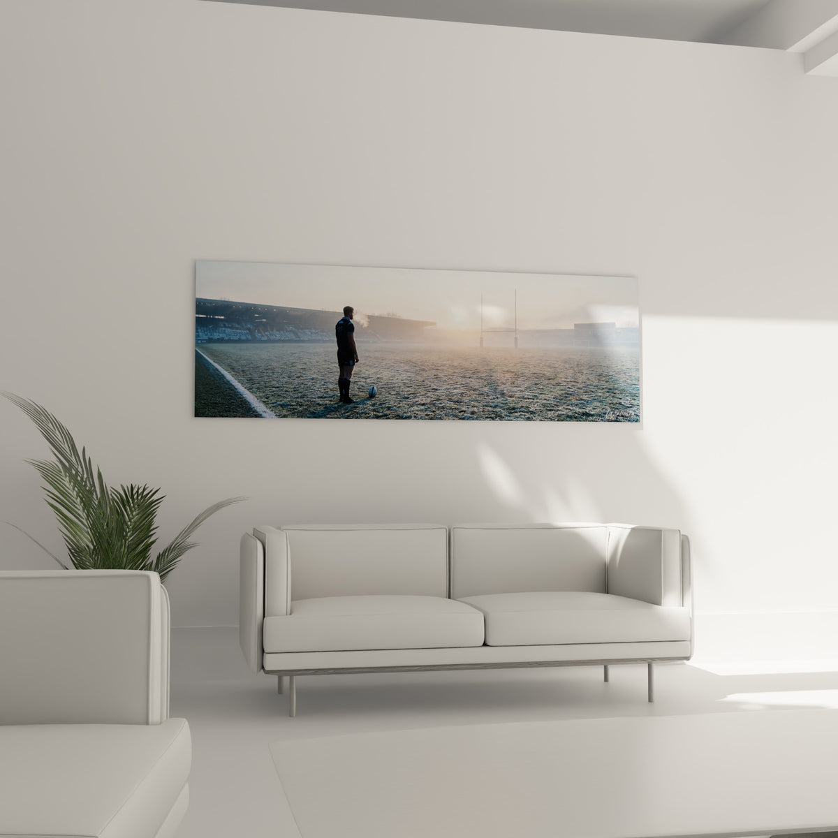 Scène de stade givré aux tons ocre et gris, tableau rugby placé au-dessus d'un canapé dans un salon lumineux