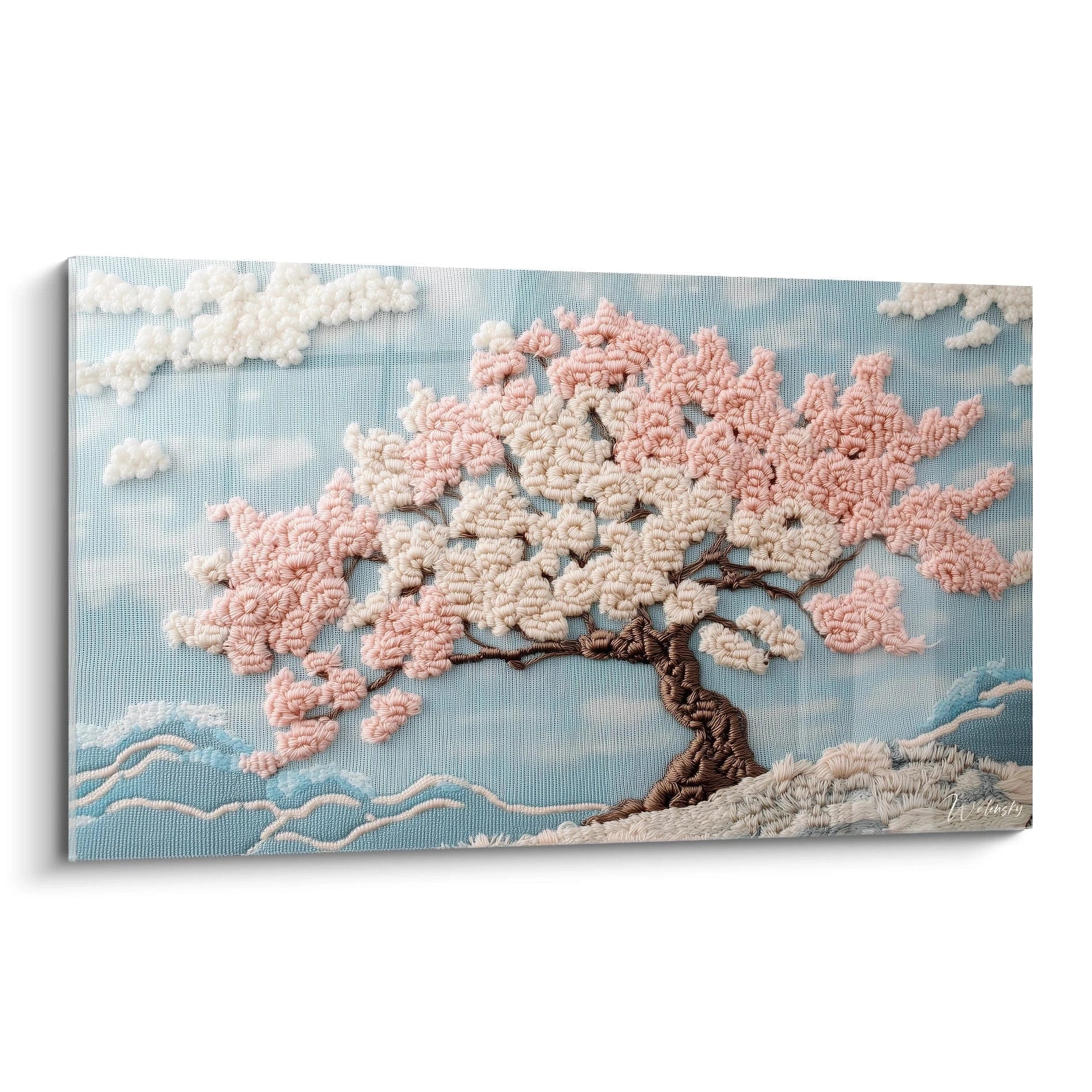 Un tableau brodé représentant un cerisier en fleurs avec un tronc marron et des branches couvertes de fleurs roses et blanches, sur fond bleu ciel avec des nuages blancs et des vagues stylisées bleues à la base, réalisé en technique crochet créant un effet de relief textile.