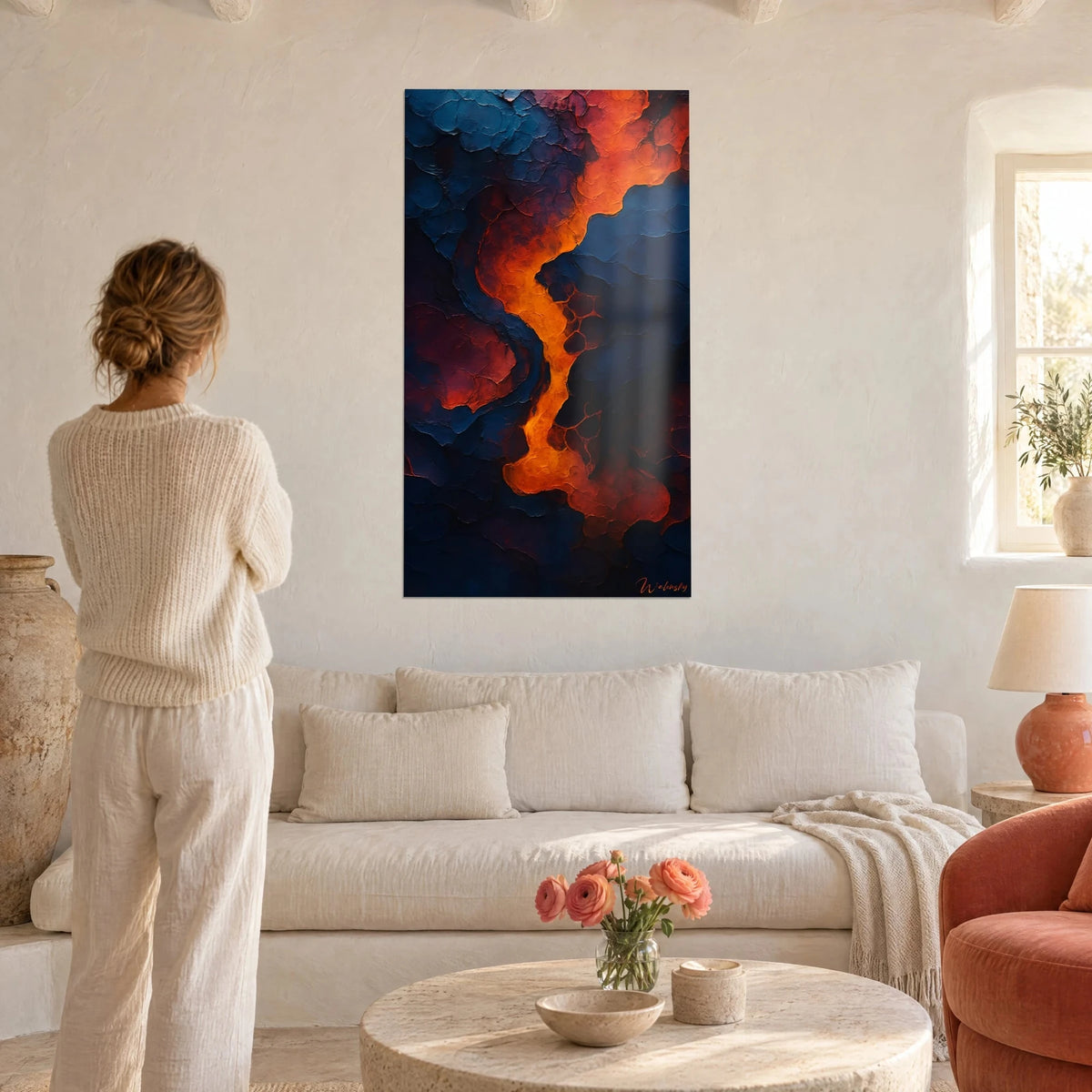 Tableau rivière de lave orange sur croûte bleu nuit en relief, femme de dos, au-dessus d'un canapé dans un salon lumineux