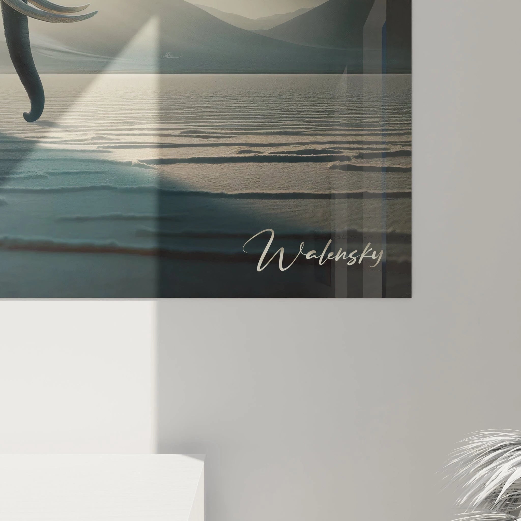 Un tableau d'animal présentant un éléphant en marche sur une surface lisse aux reflets argentés. L'atmosphère est dominée par un ciel contrasté où le soleil émerge entre des nuages gris, projetant des rayons spectaculaires sur le paysage montagneux. L'ombre allongée de l'animal se dessine nettement sur le sol à la texture striée et brillante.