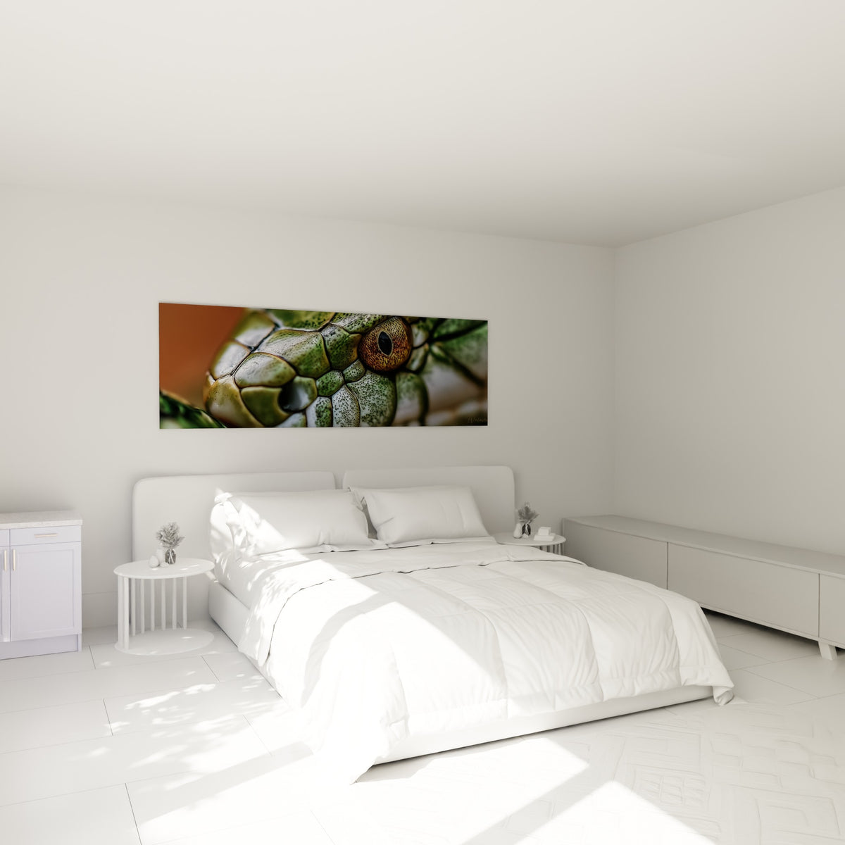 Reptile vert et ocre à l'œil perçant, tableau accroché au-dessus d'un lit dans une chambre claire.
