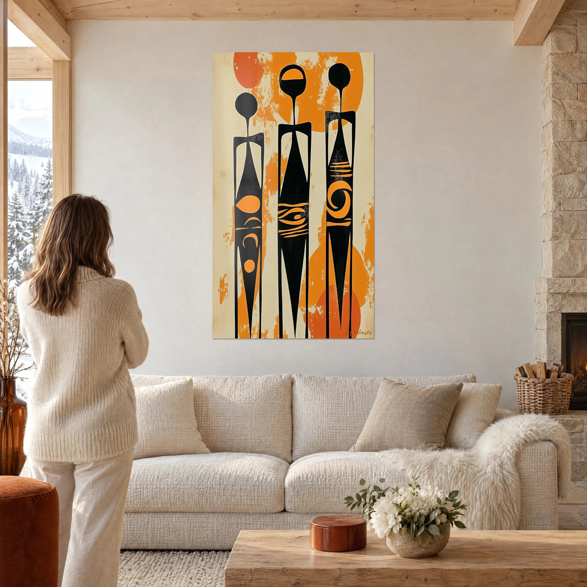 Quadro con tre sagome africane nere su sfondo beige e arancio, sopra un divano in un soggiorno luminoso