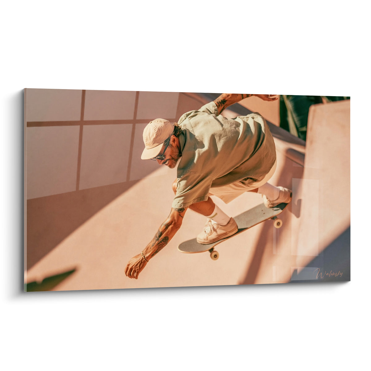 Skateur casquette beige en saut, teintes terracotta et rose, rampe éclairée au soleil couchant