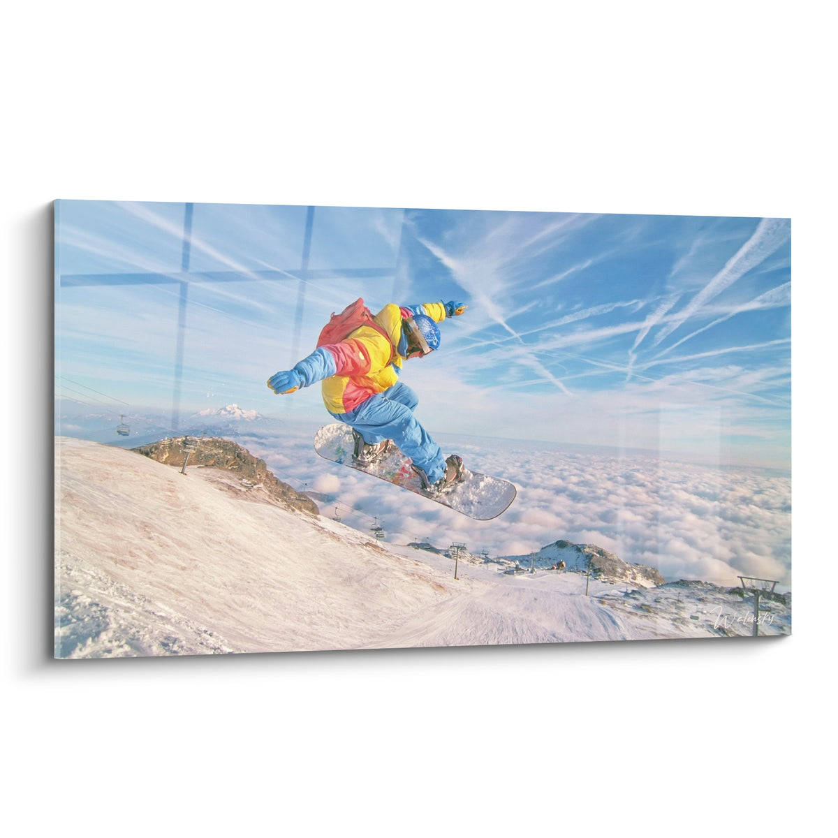 Snowboardeur en combinaison jaune et bleue sautant au-dessus des nuages blancs