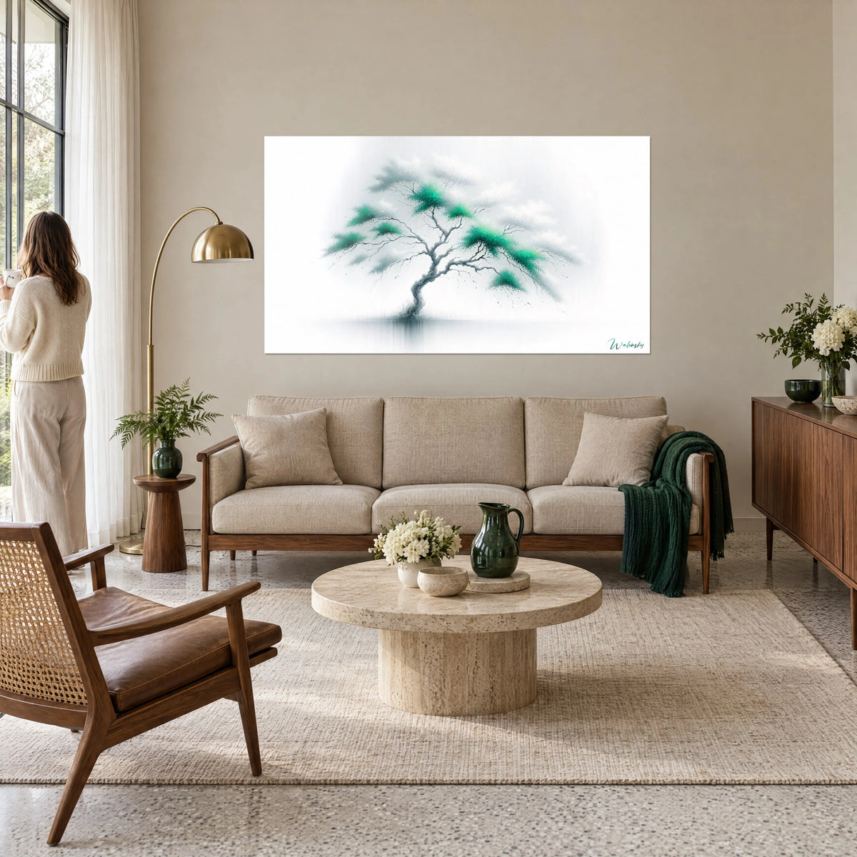 Tableau arbre tortueux aux touffes émeraude sur fond blanc brumeux, femme de dos, au-dessus d'un canapé dans un salon lumineux