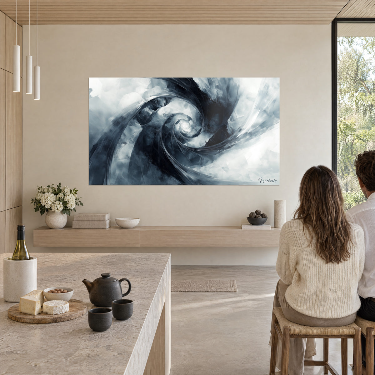 Quadro con onda astratta arrotolata in grigio perla e blu notte, centro radioso, di fronte a due persone di spalle accanto a un'isola da cucina