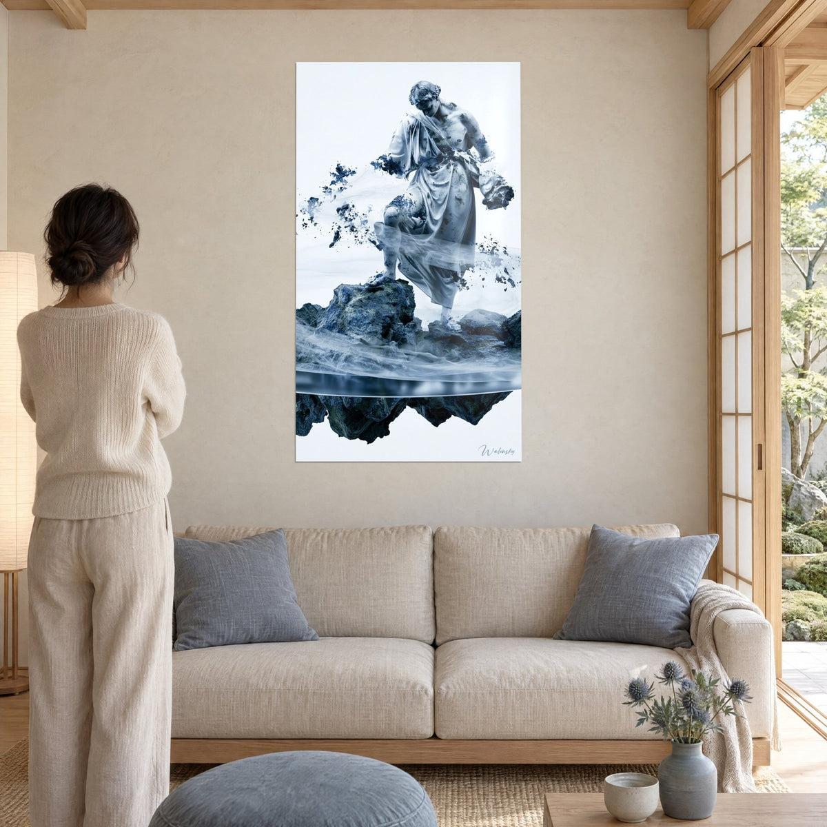 Tableau statue de marbre blanc se désagrégeant en éclats bleu cobalt sur un rocher, femme de dos, au-dessus d'un canapé dans un salon lumineux