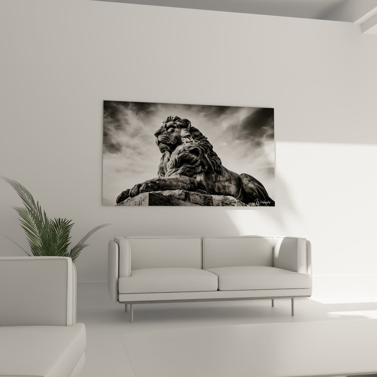 Statue de lion anthracite en contre-plongée, crinière texturée, au-dessus d'un canapé dans un salon lumineux