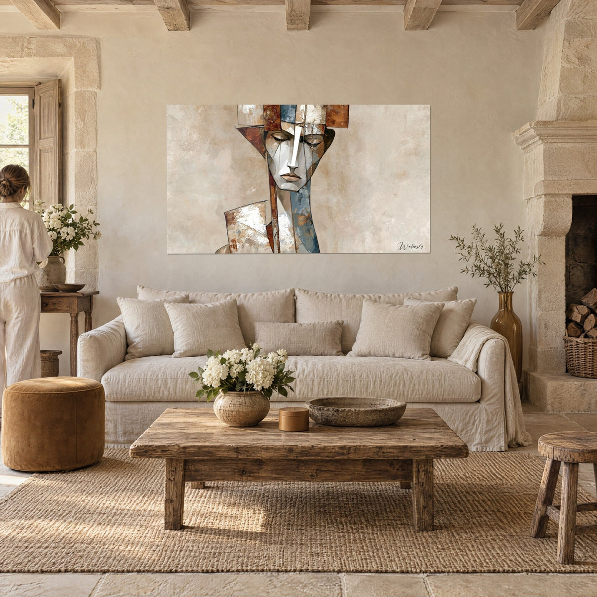 Quadro di un volto cubista con palpebre chiuse, sfaccettature bianche e ruggine su fondo beige, appeso sopra un divano in un soggiorno luminoso