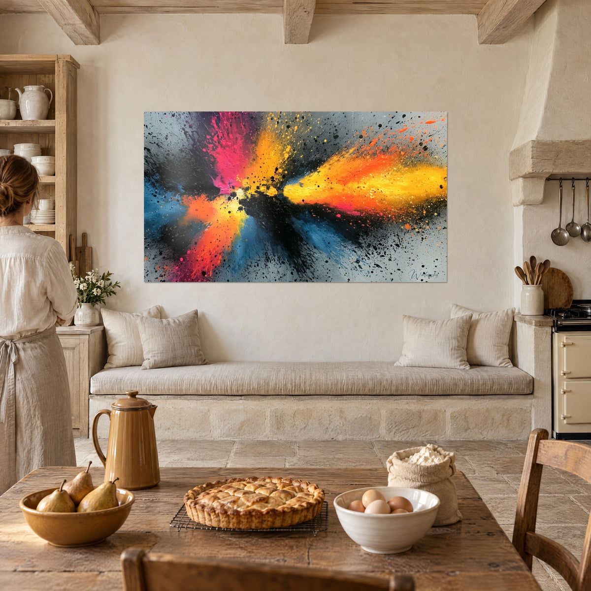Tableau déflagration de couleurs rose fuchsia et orange, gouttelettes noires, face à une cuisine en pierre où une femme de dos est debout