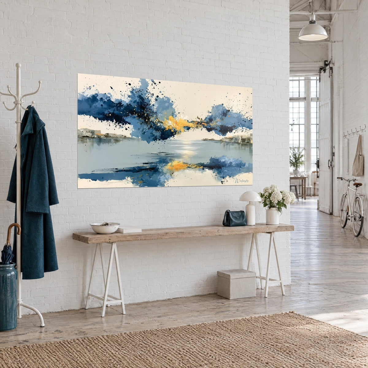 Cuadro lago abstracto con salpicaduras índigo y oro, reflejo centelleante sobre el agua gris, vista de tres cuartos en un loft