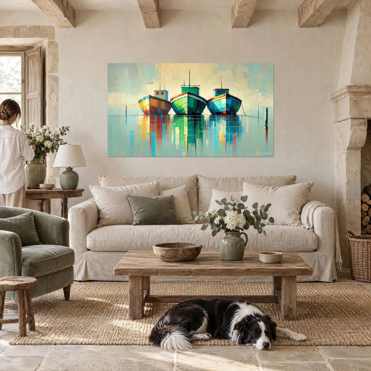 Tableau trois barques colorées amarrées, coques ocre, vertes et turquoise, reflets sur l'eau, au-dessus d'un canapé dans un salon lumineux
