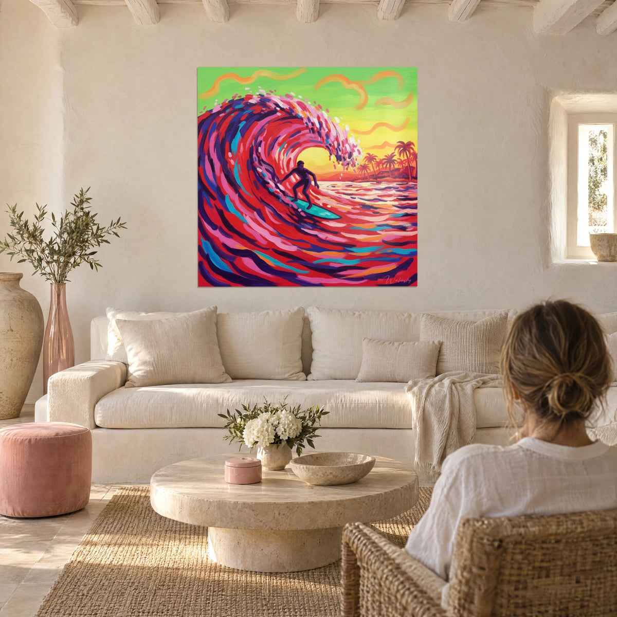 Tableau surfeur en silhouette sous un rouleau rouge et rose, ciel vert et jaune, au-dessus d'un canapé dans un salon lumineux