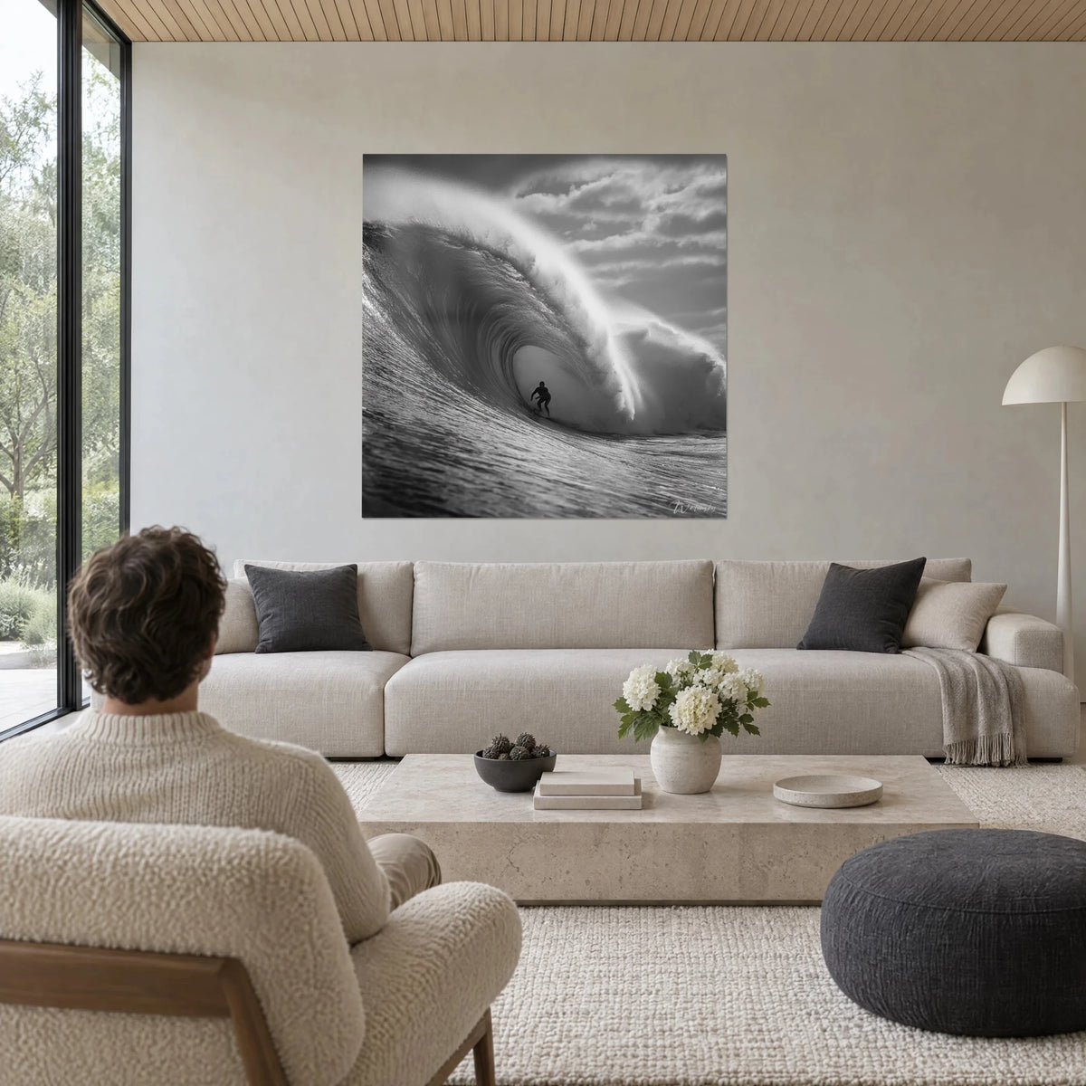 Gemälde winziger Surfer, der in der Röhre einer schwarzweißen Welle gleitet, graue schäumende Kämme, über einem Sofa in einem hellen Wohnzimmer