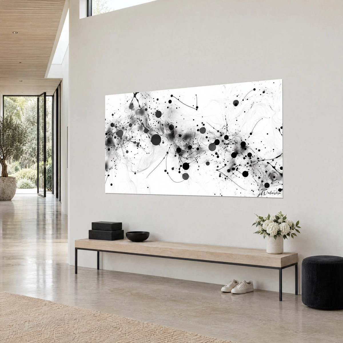 Tableau réseau de gouttes d'encre et de filaments noirs sur fond blanc, photographié de trois-quarts, au-dessus d'un banc en bois clair