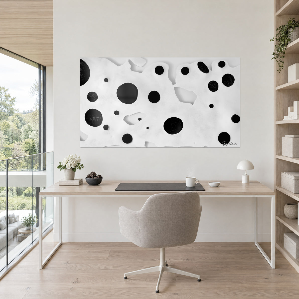 Wall art with large and small black ink bubbles on mother-of-pearl white, light wooden desk, greige chair, open shelf, green plant, glass wall