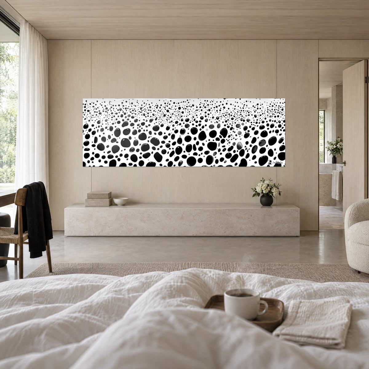 Cuadro con puntos negros irregulares sobre fondo blanco, burbujas grandes abajo, diminutas arriba, encima de una cama en un dormitorio luminoso