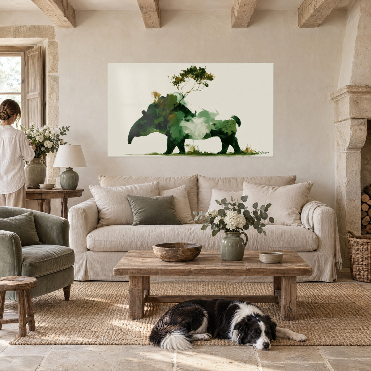 Wall art tapir in green and ochre brushstrokes, golden tree on its back, seen by a woman, reclining collie, above a sofa in a bright living room