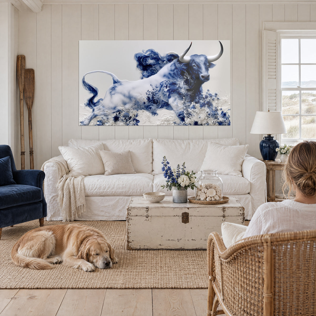Wall art white Longhorn with ivory horns, cobalt blue dress covered in thistle flowers, above a sofa in a bright living room