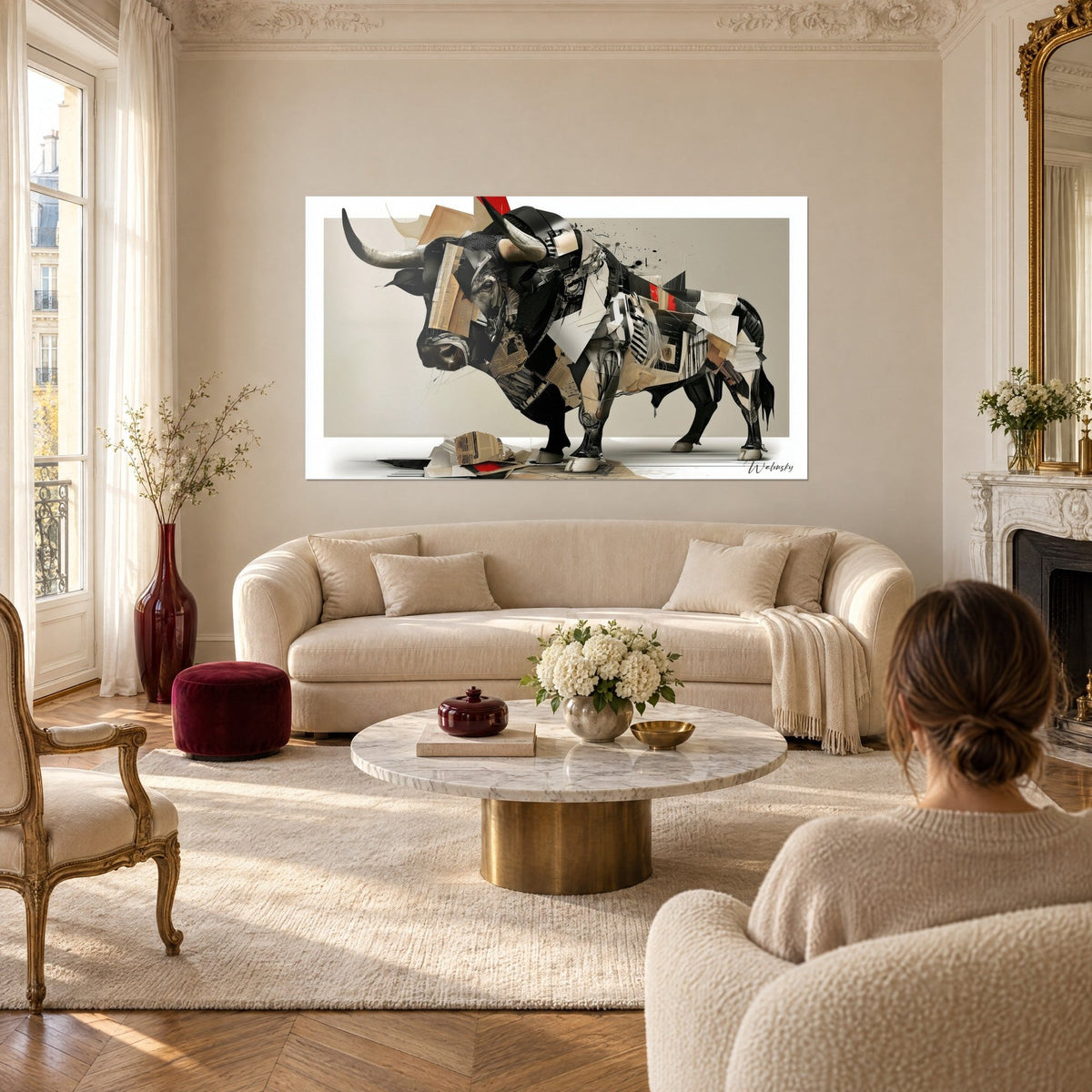 Quadro toro in collage di carte nere e beige, corna grigie, schizzi d'inchiostro, sopra un divano in un soggiorno luminoso