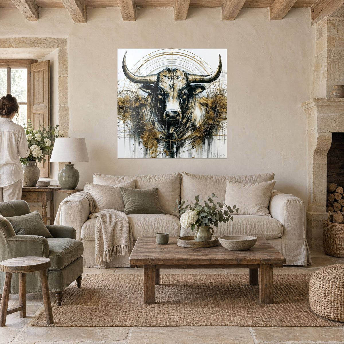 Quadro toro nero e oro con corna a mezzaluna, cerchi dorati, una donna di spalle, sopra un divano in un soggiorno luminoso
