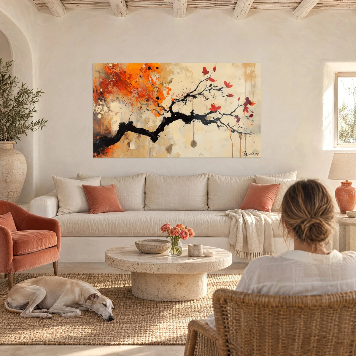 Gemälde eines schwarzen Zweigs mit roten Blütenblättern in Tintenoptik, orangefarbener und beigefarbener Hintergrund, über einem Sofa in einem hellen Wohnzimmer