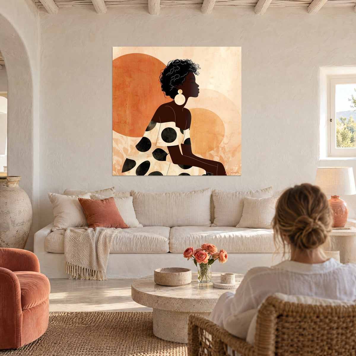 Tableau portrait de profil d'une femme à boucle d'oreille ronde, robe à pois noirs, disques terracotta, au-dessus d'un canapé dans un salon lumineux
