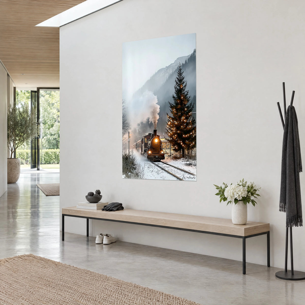Quadro di un vecchio treno sotto la neve, albero di Natale addobbato con luci ambrate e montagna grigia velata, vista di tre quarti su una parete bianca